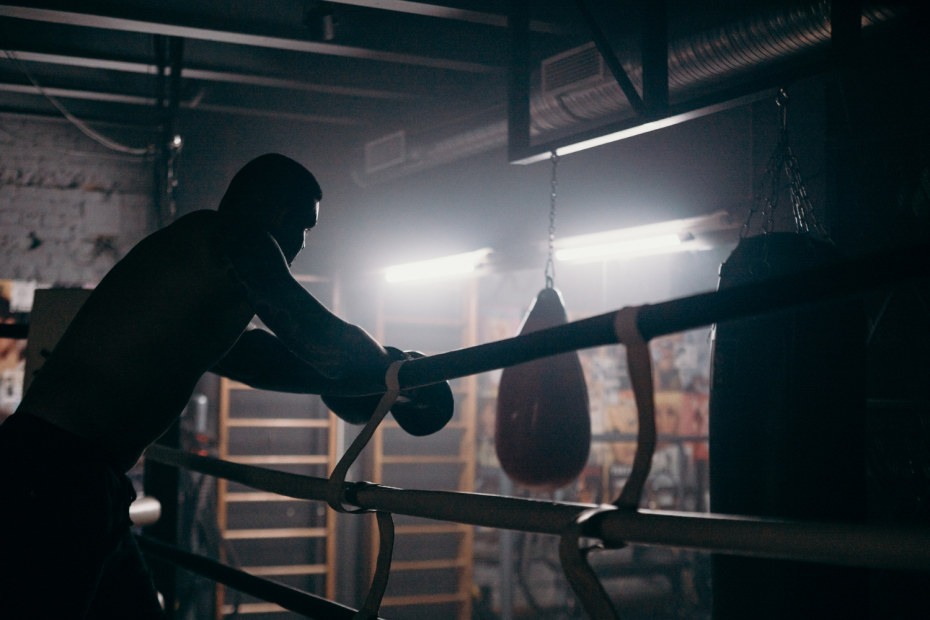 Persona viendo el gimnasio de boxeo apoyado en el ring